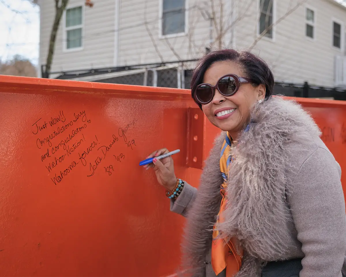 Tatia Granger, Board Member and longtime supporter of A Home for Every Hoo, signs the topping out beam