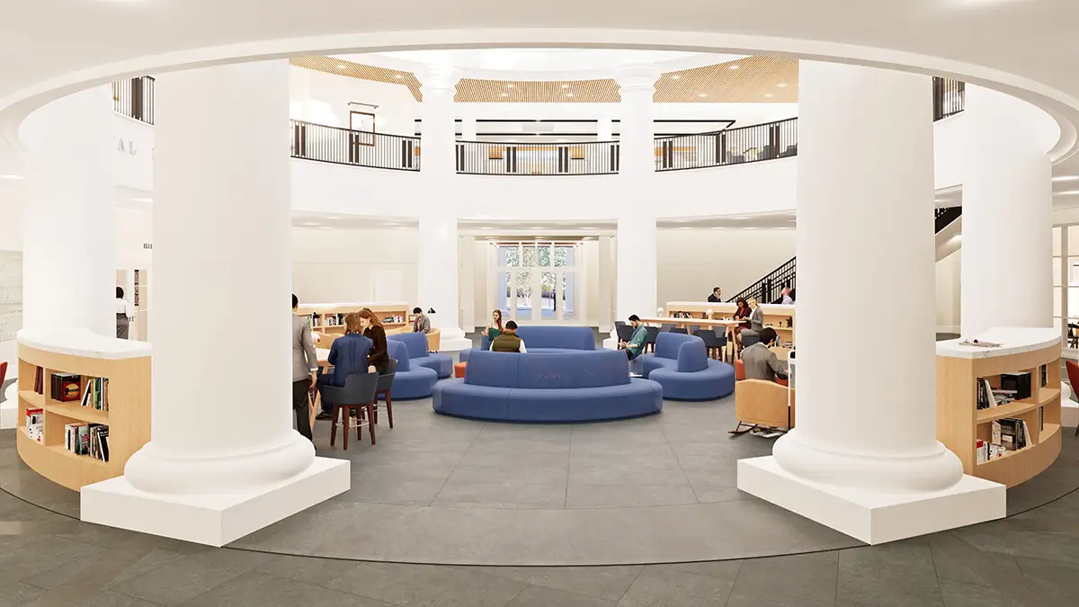 Ground floor view of the central atrium showing seating areas, tables, and bookshelves