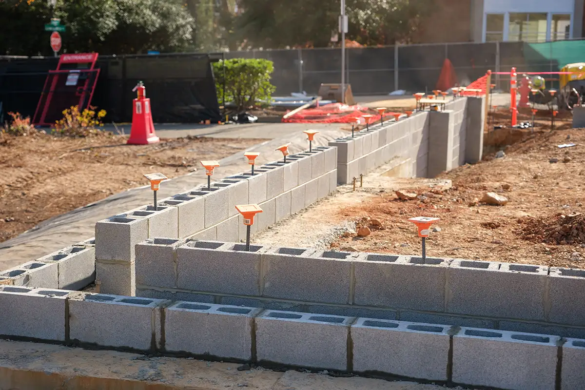 The first few courses of cinder blocks rise above ground level